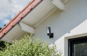 Netatmo Videocamera Esterna ORIGINAL: sicurezza 3-in-1 con registrazione locale e AI integrata Netatmo Videocamera Esterna ORIGINAL installata all’esterno con faretto LED acceso e sistema di sicurezza integrato